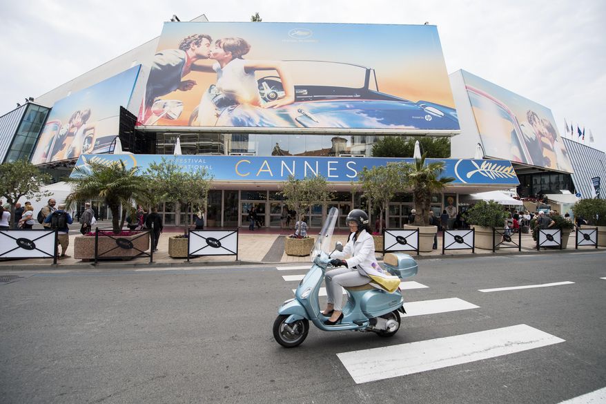 FILE - A scooter drives by the Palais des Festivals at the 71st international film festival, Cannes, southern France, on May 7, 2018. The Cannes Film Festival, canceled altogether last year by the pandemic, is postponing this year’s edition from May to July in hopes of having an in-person festival. Cannes organizers announced Wednesday that this year’s Cannes will now take place July 6-17, about two months after its typical period. (Photo by Arthur Mola/Invision/AP, File)