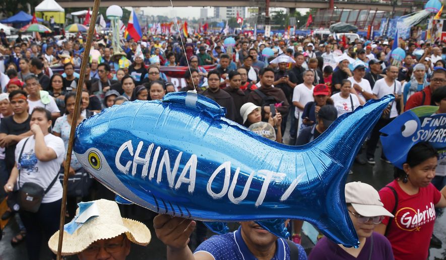 FILE - In this July 22, 2019, file photo, protesters display a balloon with an anti-China message during a rally near the Philippine Congress in Manila, Philippines. The Philippines has protested a new Chinese law that authorizes its coast guard to fire on foreign vessels and destroy other countries' structures on islands it claims, Manila’s top diplomat said Wednesday, Jan. 27, 2021. (AP Photo/Bullit Marquez, File)