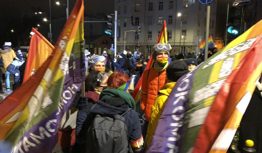 People gather in Warsaw, Poland Wednesday Jan. 27, 2021 to protest after the country's top court on Wednesday confirmed its highly divisive ruling that will further tighten the predominantly Catholic nation's strict anti-abortion law. The Constitutional Tribunal published the justification of its decision, which means it can now be officially printed and take immediate effect. (AP Photo/Czarek Sokolowski)