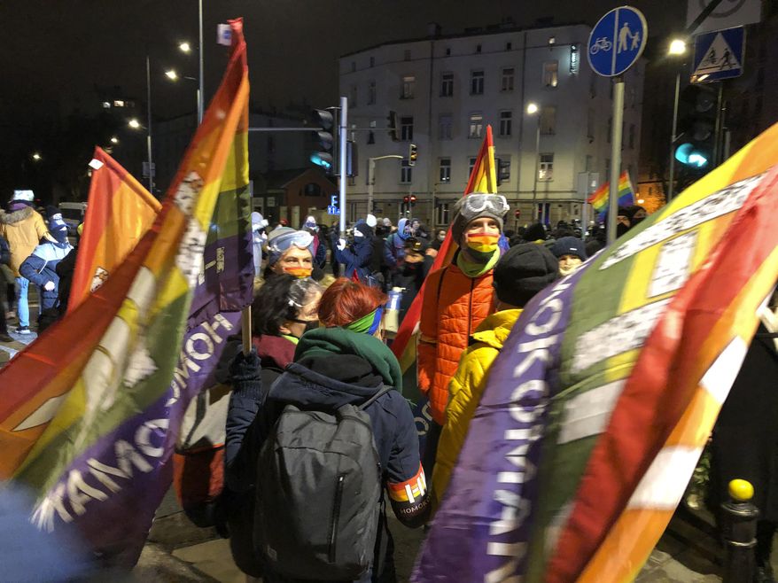People gather in Warsaw, Poland Wednesday Jan. 27, 2021 to protest after the country's top court on Wednesday confirmed its highly divisive ruling that will further tighten the predominantly Catholic nation's strict anti-abortion law. The Constitutional Tribunal published the justification of its decision, which means it can now be officially printed and take immediate effect. (AP Photo/Czarek Sokolowski)