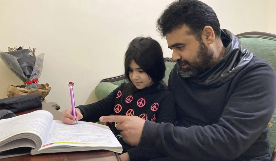 Syrian refugee Mahmoud Mansour, 47, helps his youngest daughter Sahar, 8, with her homework at his rented apartment in Amman, Jordan, Wednesday, Jan. 20, 2021. President Joe Biden has vowed to restore America&#x27;s place as a world leader in offering sanctuary to the oppressed by raising the cap on the number of refugees allowed in each year. Mansour&#x27;s family had completed the work to go to the United States when the Trump administration issued its travel ban barring people from Syria indefinitely and suspending the refugee program for 120 days. (AP Photo/Omar Akour)