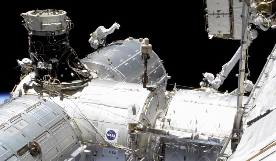 In this image taken from NASA video, NASA astronaut Mike Hopkins works outside the International Space Station’s European lab on Wednesday, Jan. 27, 2021. Hopkins and Victor Glover went spacewalking Wednesday to install a high-speed data link outside the International Space Station’s European lab and connect cables for an experiment platform awaiting activation for almost a year. (NASA via AP)