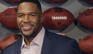 FILE - In this Thursday, Nov. 30, 2017 file photo, Former New York Giant Michael Strahan poses for a picture at the opening of &amp;quot;NFL Experience&amp;quot; in Times Square, New York. Pro Football Hall of Famer and “Good Morning America” host Michael Strahan has tested positive for COVID-19 and is self-quarantining, according to people familiar with the situation. They spoke to The Associated Press on condition of anonymity Wednesday, Jan. 27, 2021 because of medical restriction issues. (AP Photo/Seth Wenig, File)