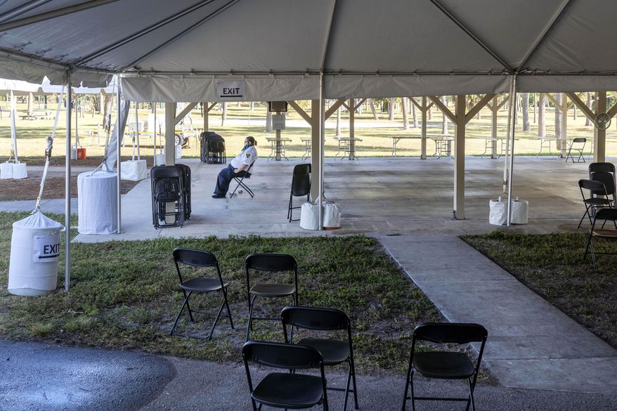 Security guard Andrea Rapini sits at a local health district appointment only vaccination site after the site closed after running out COVID-19 vaccine in Lake Worth Beach, Fla., on Wednesday, Jan. 27, 2021. (Greg Lovett/The Palm Beach Post via AP)