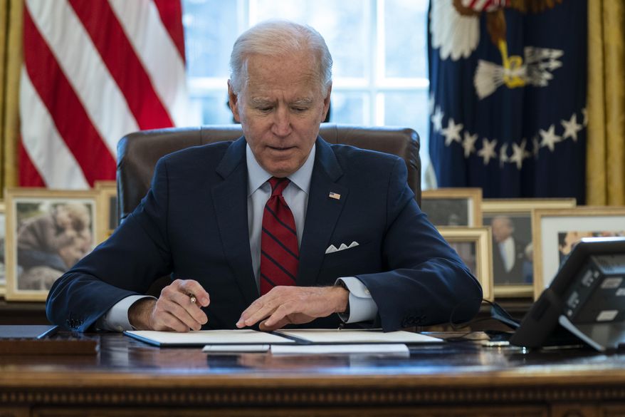 President Joe Biden signs a series of executive orders on health care, in the Oval Office of the White House, Thursday, Jan. 28, 2021, in Washington. (AP Photo/Evan Vucci)
