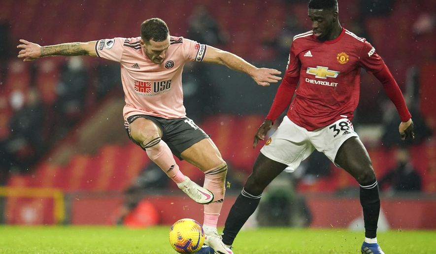 Sheffield United&#39;s Billy Sharp, left, an dManchester United&#39;s Axel Tuanzebe battle for the ball during the English Premier League soccer match between Manchester United and Sheffield United at Old Trafford, Manchester, England, Wednesday, Jan. 27, 2021. (AP Photo/Dave Thompson,Pool)