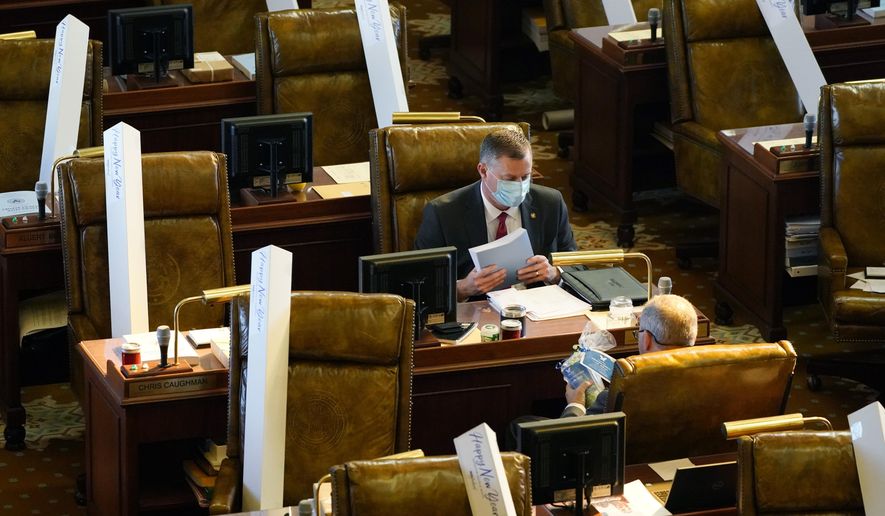 Sen. Chad McMahan, R-Guntown, moves his copy of the 2022 Mississippi Legislative Budget Report as he checks his mail at his desk during the first day of the 2021 Mississippi Legislature, Tuesday, Jan. 5, 2021, in Jackson, Miss. Lawmakers in both chambers were provided a new umbrella from a Jackson, Miss., tourism development program. (AP Photo/Rogelio V. Solis)