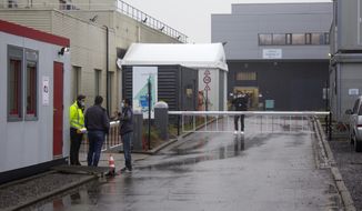 A security guard talks to people at the entrance of Novasep factory in Seneffe, Belgium, Thursday, Jan. 28, 2021. Belgian health authorities said Thursday they have inspected a pharmaceutical factory located in Belgium to find out whether the expected delays in the deliveries of AstraZeneca&#39;s coronavirus vaccines are due to production issues. The Novasep factory in the town of Seneffe is part of the European production chain for AstraZeneca&#39;s coronavirus vaccine. (AP Photo/Mark Carlson)