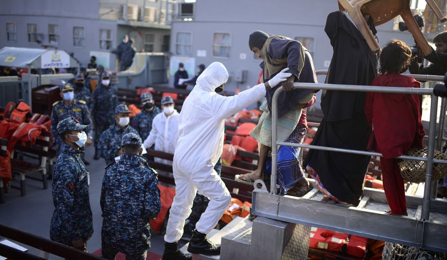 FILE - In this Tuesday, Dec. 29, 2020 file photo Rohingya refugees board a naval ship to be transported to an isolated island in the Bay of Bengal, in Chittagong, Bangladesh. Countries with the least corruption have been best positioned to weather the health and economic challenges of the coronavirus pandemic, according to a closely-watched annual study released Thursday by anti-graft watchdog organization Transparency International. Bangladesh, which scored 26 and placed 146th on the list, “invests little in health care while corruption flourishes during COVID-19, ranging from bribery in health clinics to misappropriated aid,” Transparency wrote. (AP Photo/Mahmud Hossain Opu, file)