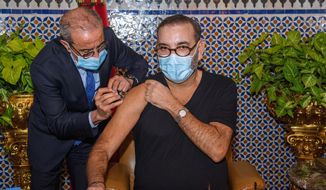 In this photo released by the Royal Palace, Morocco&#39;s King Mohammed VI, right, receives the COVID-19 vaccine at the Royal Palace in Fes, as he launches his country&#39;s coronavirus vaccination campaign, Thursday Jan. 28, 2021. The North African kingdom received its first shipments of vaccine doses in recent days from China&#39;s Sinopharm and Anglo-Swedish drug maker AstraZeneca. (Moroccan Royal Palace via AP)