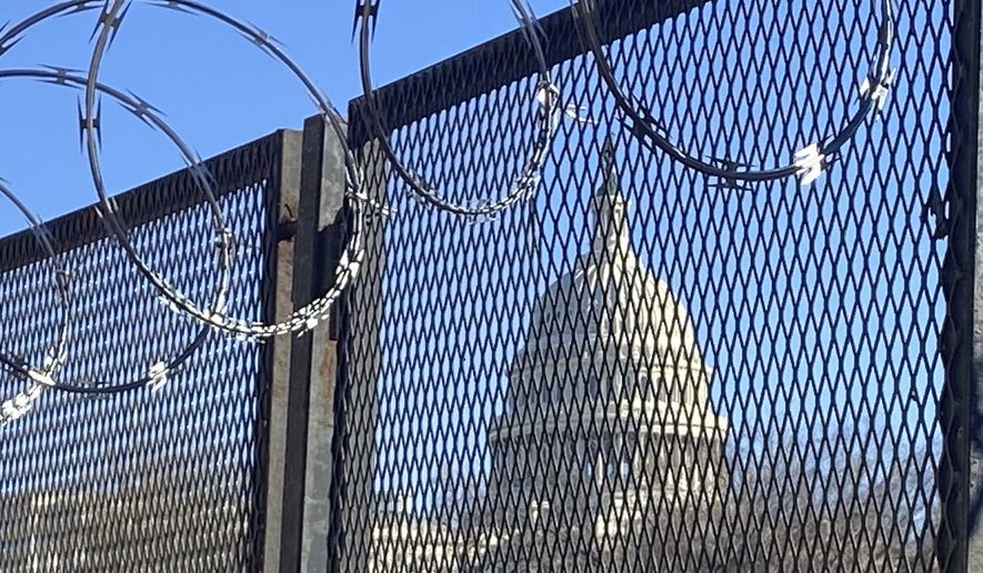 In this Saturday, Jan. 23, 2021 photo, riot fencing and razor wire reinforce the security zone on Capitol Hill in Washington. (AP Photo/Eileen Putman)