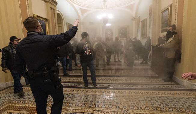 Smoke fills the walkway outside the Senate Chamber as supporters of President Donald Trump are confronted by U.S. Capitol Police officers inside the Capitol in Washington. (AP Photo/Manuel Balce Ceneta, File)