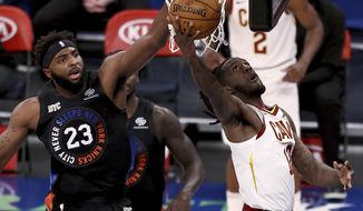 Cleveland Cavaliers&#39; Taurean Prince heads for the basket as New York Knicks&#39; Mitchell Robinson (23) defends during the first quarter of an NBA basketball game Friday, Jan. 29, 2021, in New York. (Elsa/Pool Photo via AP)