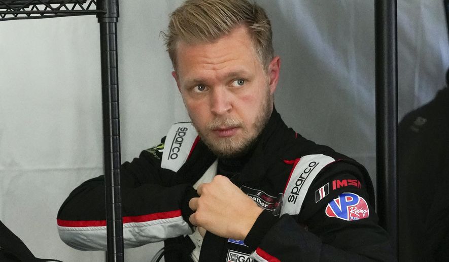 Kevin Magnussen, of Denmark, adjusts his driving suit after taking a turn on the track driving during a practice session for the Rolex 24 hour race at Daytona International Speedway, Friday, Jan. 29, 2021, in Daytona Beach, Fla. (AP Photo/John Raoux)