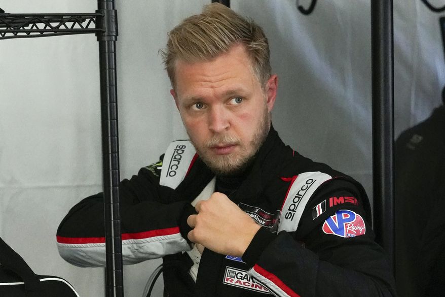 Kevin Magnussen, of Denmark, adjusts his driving suit after taking a turn on the track driving during a practice session for the Rolex 24 hour race at Daytona International Speedway, Friday, Jan. 29, 2021, in Daytona Beach, Fla. (AP Photo/John Raoux)