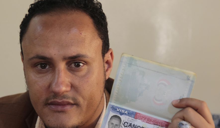 Mohammed Al Zabidi holds his canceled U.S. visa at his home in Sanaa, Yemen, on Thursday, Jan. 28, 2021. The Trump administration’s travel ban that affected several Muslim-majority nations robbed him of his American dream and his chance to escape his war-torn homeland. With a new president at the helm, the ban is over, but Al Zabidi’s plight isn’t. (AP Photo/Hani Mohammed)
