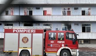 A fire engine is parked a hospital after a fire broke out on the ground floor Friday Jan. 29, 2021. Authorities in Romania say the fire at the key hospital in Bucharest that also treats COVID-19 patients has caused less than 5 fatalities and forced the evacuation of the building that houses 100 people. (AP Photo/Vadim Ghirda)