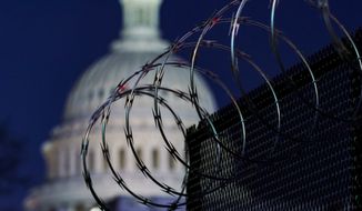In this Jan. 19, 2021 photo, riot fencing and razor wire reinforce the security zone on Capitol Hill in Washington. The Capitol Police say they are stepping up security at Washington-area transportation hubs and taking other steps to bolster travel security for lawmakers. The moves come as Congress continues to react to this month&#39;s deadly assault on the Capitol. (AP Photo/J. Scott Applewhite)