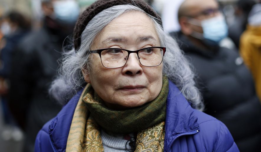Tran To Nga, a 78-year-old former journalist, attends a gathering in support of people exposed to Agent Orange during the Vietnam War, in Paris, Saturday Jan. 30, 2021. Activists gathered Saturday in Paris in support of people exposed to Agent Orange during the Vietnam War, after a French court examined a case opposing a French-Vietnamese woman to 14 companies that produced and sold the toxic chemical. (AP Photo/Thibault Camus)