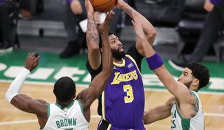 Los Angeles Lakers&#39; Anthony Davis (3) shoots between Boston Celtics&#39; Jaylen Brown (7) and Jayson Tatum during the first half of an NBA basketball game Saturday, Jan. 30, 2021, in Boston. (AP Photo/Michael Dwyer)