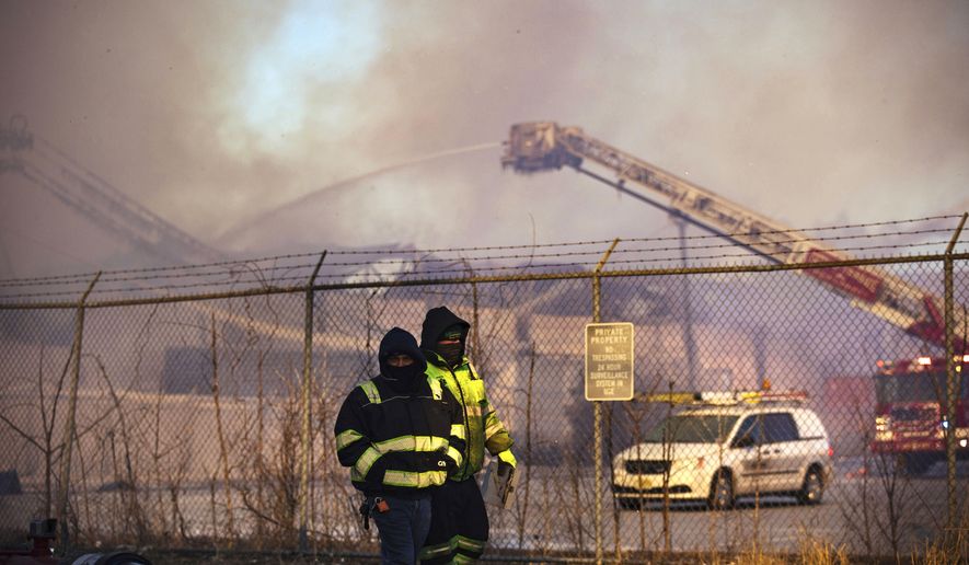 Firefighters battle a blaze in an industrial area on Saturday, Jan. 30, 2021, in Passaic, NJ. The multi-alarm fire in a recycling plant started after midnight and burned into the morning. (AP Photo/Kevin Hagen).