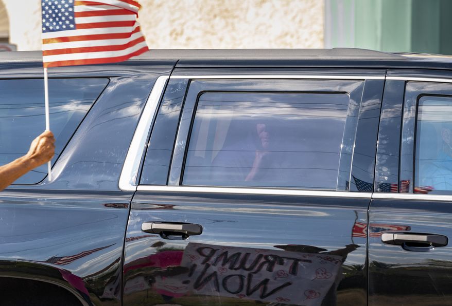 Former President Donald Trump passes supporters while traveling in his motorcade in West Palm Beach, Fla., on Wednesday, Jan. 27, 2021, on his way to Mar-a-Lago in Palm Beach. (Greg Lovett/The Palm Beach Post via AP)