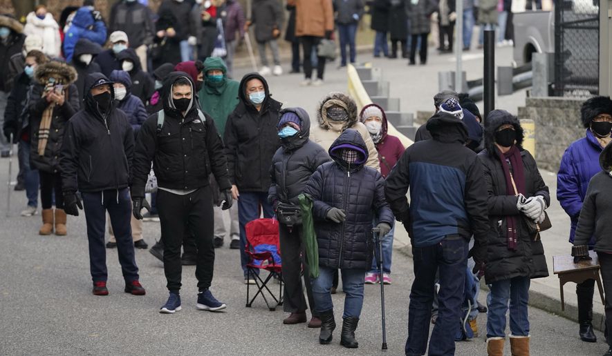 FILE - In this Jan. 21, 2021, file photo, people wait in line for the COVID-19 vaccine in Paterson, N.J. A racial gap has opened up in the nation's COVID-19 vaccination drive, with Black Americans in many places lagging behind whites in receiving shots, an Associated Press analysis shows. (AP Photo/Seth Wenig, File)