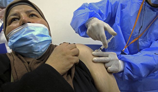 A woman receives the Sputnik-V COVID-19 vaccine at a vaccination center in Blida, south of Algiers, Algeria, Saturday, Jan. 30, 2021. The vaccines were delivered to the Boufarik military airport west of Algiers, Minister Amar Belhimeur said in a statement. He did not indicate how many arrived, though the government had said it had ordered a first batch of 500,000 Sputnik doses. (AP Photo/Fateh Guidoum)