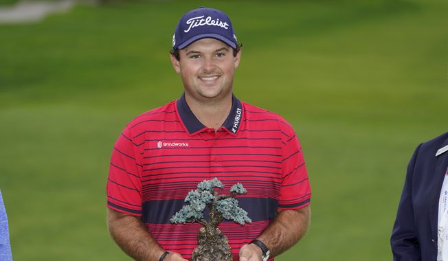 Patrick Reed stands on the South Course while holding his trophy for winning the Farmers Insurance Open golf tournament at Torrey Pines, Sunday, Jan. 31, 2021, in San Diego. (AP Photo/Gregory Bull)