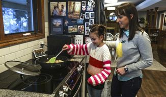 CORRECTS TO MISSY MILLARD-Missy Millard, left, cooks with her mom, Kim, in their home in Layton on Thursday, Jan. 28, 2021. (Annie Barker/The Deseret News via AP)