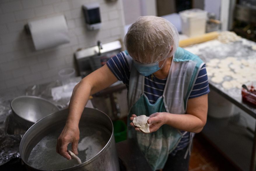 Teresa Wosiak boils new paczki-pierogi desserts for the Polish Village Cafe, Monday, Jan. 25, 2021, in Hamtramck, Mich. (Antranik Tavitian/Detroit Free Press via AP)