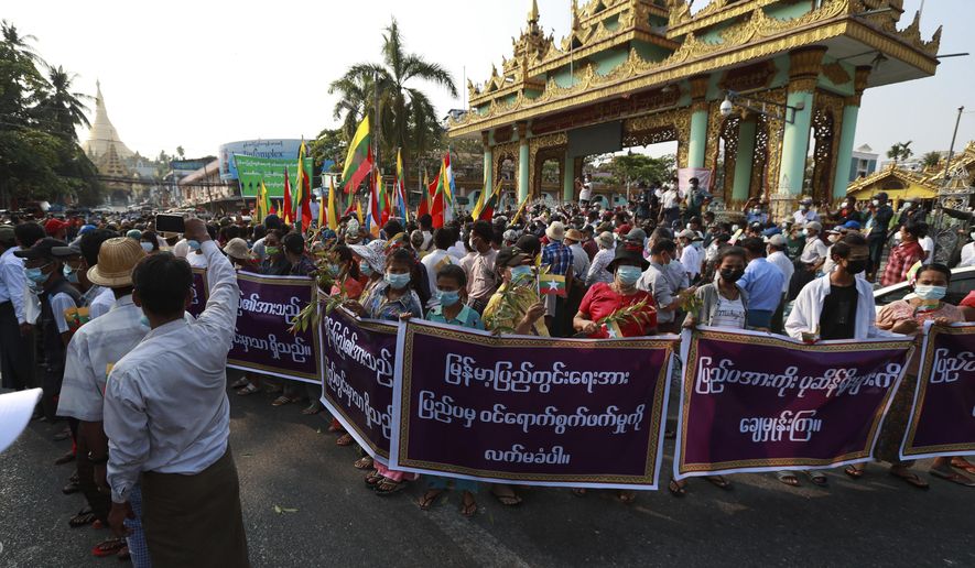 Supporters of the Myanmar military and the military-backed Union Solidarity and Development Party hold placards that read "Do not accept interference by foreign countries. Wipe out those relying on external elements." as they continue to protest election results during a rally near Shwedagon pagoda Saturday, Jan. 30, 2021, in Yangon, Myanmar. Myanmar’s military has denied that controversial statements by its chief were meant as a threat to stage a coup, claiming the media had misinterpreted his words. Political tension soared this past week after the military said it could not rule out a coup if its complaints of widespread voting fraud in last November’s election were ignored. (AP Photo/Thein Zaw)