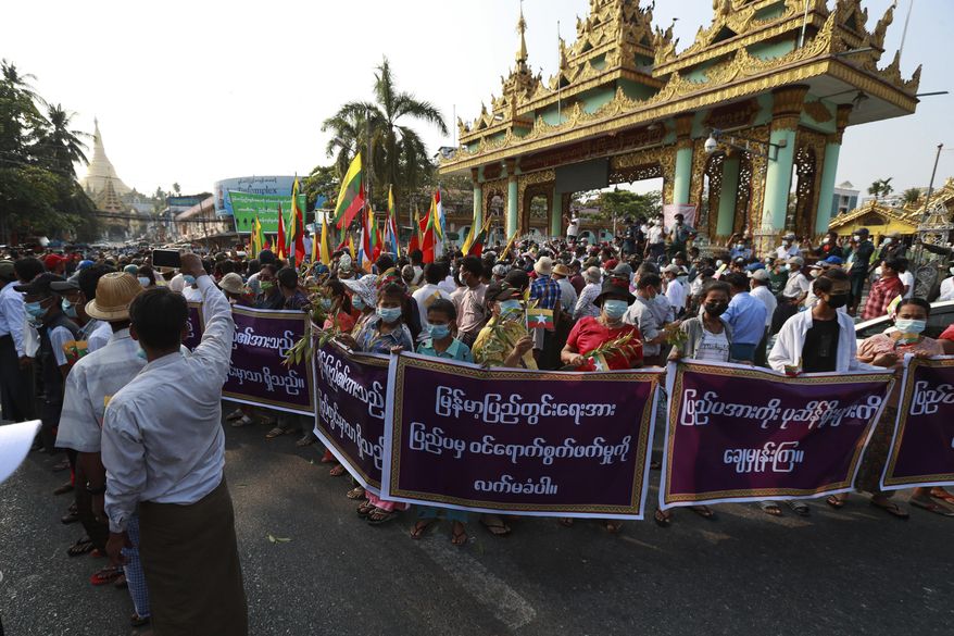 Supporters of the Myanmar military and the military-backed Union Solidarity and Development Party hold placards that read "Do not accept interference by foreign countries. Wipe out those relying on external elements." as they continue to protest election results during a rally near Shwedagon pagoda Saturday, Jan. 30, 2021, in Yangon, Myanmar. Myanmar’s military has denied that controversial statements by its chief were meant as a threat to stage a coup, claiming the media had misinterpreted his words. Political tension soared this past week after the military said it could not rule out a coup if its complaints of widespread voting fraud in last November’s election were ignored. (AP Photo/Thein Zaw)