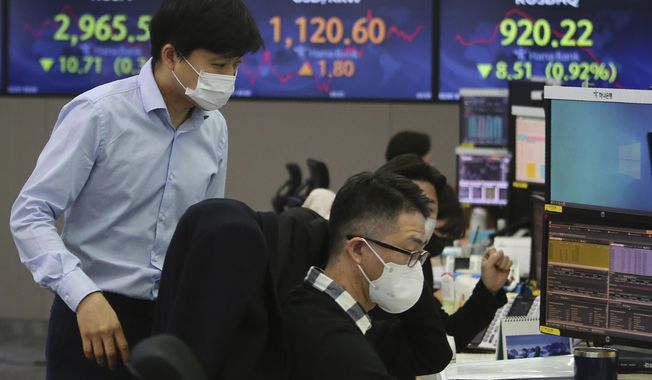 Currency traders watch monitors at the foreign exchange dealing room of the KEB Hana Bank headquarters in Seoul, South Korea, Monday, Feb. 1, 2021. Asian stock markets gained Monday after coronavirus vaccine maker AstraZeneca agreed to increase supplies to Europe amid rising worries about the disease. (AP Photo/Ahn Young-joon)