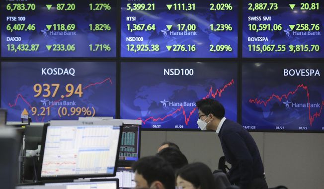 A currency trader watches monitors at the foreign exchange dealing room of the KEB Hana Bank headquarters in Seoul, South Korea, Monday, Feb. 1, 2021. Asian stock markets gained Monday after coronavirus vaccine maker AstraZeneca agreed to increase supplies to Europe amid rising worries about the disease. (AP Photo/Ahn Young-joon)