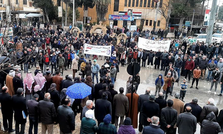 In this photo released by the Syrian official news agency SANA, pro-government demonstrators protest the siege on their neighborhood by Kurdish security forces, in Hassakeh, Syria, Sunday, Jan. 31, 2021. The state news agency SANA said one Syrian was killed and four injured after Kurdish security forces opened fire at pro-government demonstrators in Hassakeh. A Kurdish-run news agency, Hawar, said security forces at a checkpoint in the city had come under fire, prompting its members to respond to the source of fire that led to the death of a government security member. (SANA via AP)