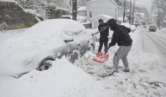 Frank White, of Fort Lauderdale, Florida, front, and Devine Marks, of Pottsville, Pa., shovel out a car on E. Norwegian Street in Pottsville, Pa., on Monday, Feb. 1, 2021. (Jacqueline Dormer/Republican-Herald via AP)