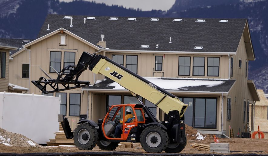 FILE - In this Dec. 1, 2020 file photo, workers toil on new homes under construction in a development near Chatfield State Park in Littleton, Colo. Spending on U.S. construction projects increased 0.9% in November as strength in home building offset weakness in other parts of the construction industry. The Commerce Department said that the November gain followed a bigger 1.6% rise in October and left construction spending up 4.4% through the first 11 months of 2020 compared to the same period in 2019. (AP Photo/David Zalubowski, File)