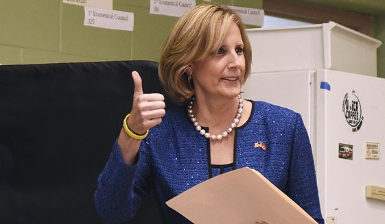 In this Nov. 6, 2018, file photo, Republican Congresswoman Claudia Tenney signals she successfully cast her ballot after voting at St. George's Church in New Hartford, N.Y. Tenney appeared on the verge of recapturing her old seat in Congress as election officials wrapped up counting ballots Monday, Feb. 1, 2021, in the nation's last undecided U.S. House race. (AP Photo/Heather Ainsworth, File)