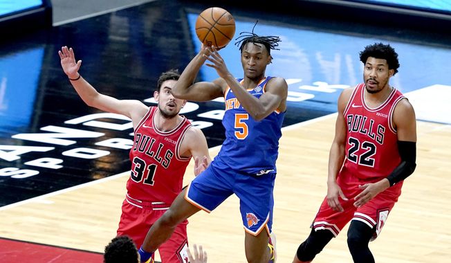 New York Knicks&#x27; Immanuel Quickley (5) looks to pass between the defense of Chicago Bulls&#x27; Tomas Satoransky (31) and Otto Porter Jr. during the first half of an NBA basketball game Monday, Feb. 1, 2021, in Chicago. (AP Photo/Charles Rex Arbogast)