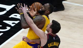 Los Angeles Lakers forward LeBron James, top, is fouled by Atlanta Hawks forward Danilo Gallinari (8) as he goes to the basket in the second half of an NBA basketball game Monday, Feb. 1, 2021, in Atlanta. (AP Photo/John Bazemore)