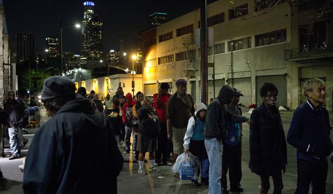 FILE - In this Sept. 19, 2017, file photo, people line up for free food being given out in an area of downtown Los Angeles known as Skid Row. A fed up federal judge says a rain storm during the last week of January 2021 created &amp;quot;extraordinarily harsh&amp;quot; conditions for homeless residents of Los Angeles and he has ordered city officials to meet with him at a Skid Row shelter to discuss how to address the worsening crisis of people living on the streets. (AP Photo/Jae C. Hong,File)