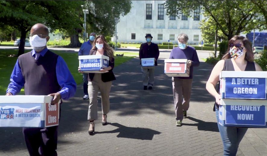 FILE - In this June 26, 2020, file photo taken from video, provided by the Yes on Measure 110 Campaign, volunteers deliver boxes containing signed petitions in favor of the measure to the Oregon Secretary of State's office in Salem, Ore. The measure said the U.S., possession of small amounts of heroin, cocaine, LSD and other hard drugs would be decriminalized in Oregon. Police in Oregon can no longer arrest someone for possession of small amounts of heroin, methamphetamine and other hard drugs as the ballot measure that decriminalized them took effect on Monday, Feb. 1, 2021. (Yes on Measure 110 Campaign via AP, File)