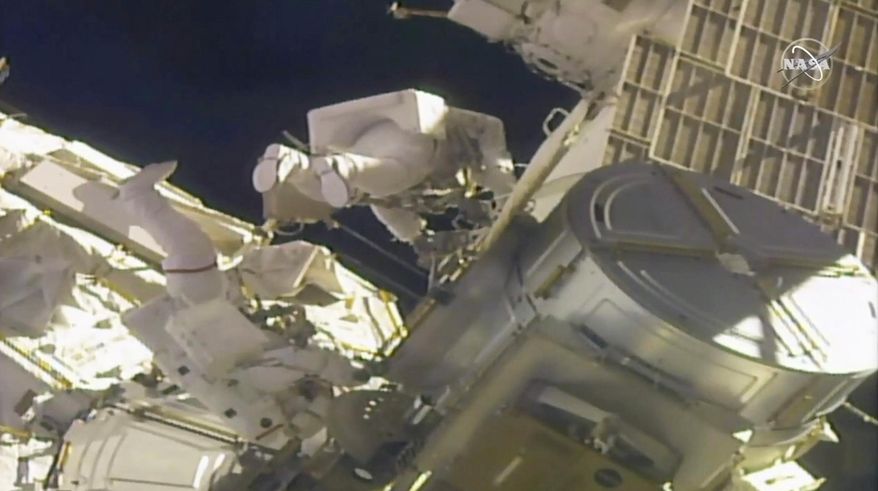 In this image taken from NASA video, NASA astronauts Mike Hopkins, left, and Victor Glover work outside the International Space Station on Monday, Feb. 1, 2021. The pair ventured out on their second spacewalk in under a week Monday to complete a four-year effort to modernize the International Space Station's power grid. (NASA via AP)