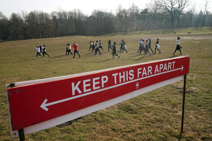 Curly Shirley Catton's exercise class walks through the Nethermead, a meadow, Thursday, Jan. 14, 2021, in Brooklyn's Prospect Park in New York. (AP Photo/Kathy Willens)