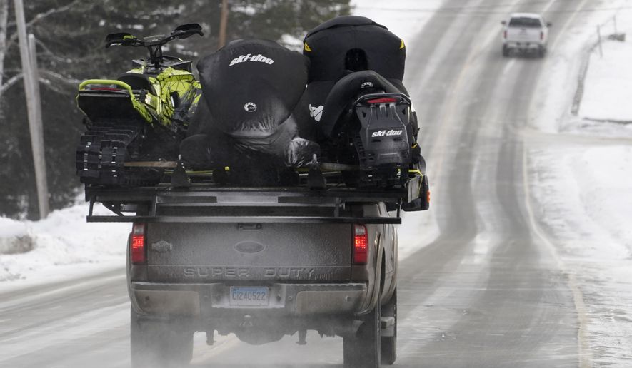 A truck carries snowmobiles, Saturday, Jan. 23, 2021, in Rangeley, Maine. Americans&#39; desire to get outdoors during the pandemic despite the winter cold is creating a season unlike any in more than two decades for the snowmobiling industry. From Maine to Montana, it’s becoming difficult to find a new snowmobile for sale AP Photo/Robert F. Bukaty)