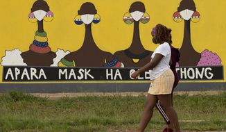 A woman walks past a coronavirus-themed mural promoting the use of face mask in public place, in Sebokeng, Vereeniging, South Africa, Thursday, Jan. 28, 2021. (AP Photo/Themba Hadebe)