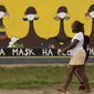 A woman walks past a coronavirus-themed mural promoting the use of face mask in public place, in Sebokeng, Vereeniging, South Africa, Thursday, Jan. 28, 2021. (AP Photo/Themba Hadebe)