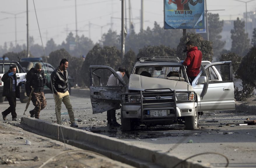 Security personnel inspect the site of a bomb attack in Kabul, Afghanistan, Tuesday, Feb. 2, 2021. A roadside bomb exploded Tuesday in the capital, Kabul, wounding several people. (AP Photo/Rahmat Gul)