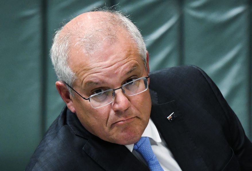 Australian Prime Minister Scott Morrison sits in the House of Representatives during question time at Parliament House in Canberra, Tuesday, Feb. 2, 2021. Morrison said there could be more targeted economic relief for businesses struggling with pandemic restrictions after Parliament resumed for the first time in 2021. (Lukas Coch/AAP Image via AP)